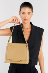 Profile view of model wearing the Oroton Elm Medium Satchel Bag in Mushroom and Smooth Pebble Leather for Women