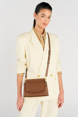 Profile view of model wearing the Oroton Elm Small Satchel Bag in Tan and Smooth Pebble Leather for Women