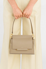 Profile view of model wearing the Oroton Elm Small Satchel Bag in Mushroom and Smooth Pebble Leather for Women