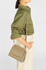 Profile view of model wearing the Oroton Elm Small Satchel Bag in Mushroom and Smooth Pebble Leather for Women