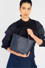 Profile view of model wearing the Oroton Polly Small Tote in Dark Navy and Pebble Leather for Women