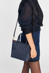Profile view of model wearing the Oroton Polly Small Tote in Dark Navy and Pebble Leather for Women