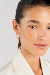 Profile view of model wearing the Oroton Kimberley Pearl Charm Hoop Earrings in Gold/Pearl and Brass for Women