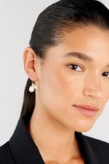 Profile view of model wearing the Oroton Kimberley Pearl Charm Hook Earrings in Gold/Pearl and Brass for Women