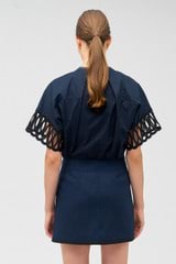 Profile view of model wearing the Oroton Lace Trim Blouse in North Sea and 100% cotton for Women
