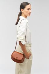 Profile view of model wearing the Oroton Della Saddle Shoulder Bag in Syrup and Smooth leather for Women