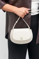 Profile view of model wearing the Oroton Della Saddle Shoulder Bag in Clotted Cream and Smooth leather for Women