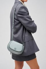 Profile view of model wearing the Oroton Della Saddle Shoulder Bag in Grey Flannel and Smooth leather for Women