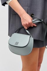 Profile view of model wearing the Oroton Della Saddle Shoulder Bag in Grey Flannel and Smooth leather for Women