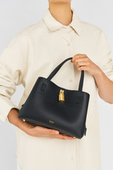 Profile view of model wearing the Oroton Tate Small Three Pocket Day Bag in Black and Pebble leather for Women