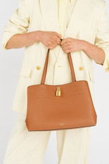 Profile view of model wearing the Oroton Tate Three Pocket Day Bag in Brandy and Pebble leather for Women