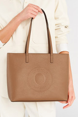 Profile view of model wearing the Oroton Polly Medium Zip Tote in Tan and Pebble Leather for Women