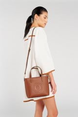 Profile view of model wearing the Oroton Polly Smooth Small Tote in Cognac and Smooth leather fused with saffiano PU for Women