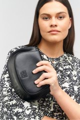 Profile view of model wearing the Oroton Della Saddle Shoulder Bag in Black and Smooth leather for Women