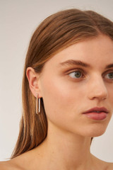 Profile view of model wearing the Oroton Lacey Large Hoops in Silver and Brass for Women