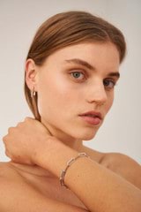 Profile view of model wearing the Oroton Lacey Medium Hoops in Silver and Brass for Women