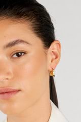 Profile view of model wearing the Oroton Leah Hoop Earrings in Gold and Stainless Steel for Women