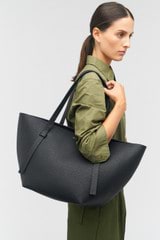 Profile view of model wearing the Oroton Ellis Medium Tote in Black and Pebble leather for Women