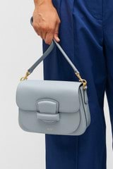 Profile view of model wearing the Oroton Carter Small Day Bag in Dusk Blue and Smooth leather for Women