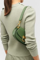 Profile view of model wearing the Oroton Colt Small Baguette in Moss and Smooth leather for Women