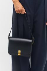 Profile view of model wearing the Oroton Etta Large Day Bag in Black and Smooth leather for Women