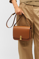 Profile view of model wearing the Oroton Etta Large Day Bag in Amber and Smooth leather for Women