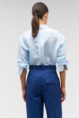 Profile view of model wearing the Oroton Sheer Stripe Shirt in Delft Blue and 75% cotton, 25% silk for Women