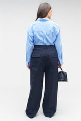 Profile view of model wearing the Oroton Pleat Pant in North Sea and 98%  wool, 2% elastane for Women