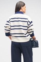 Profile view of model wearing the Oroton Stripe Polo in North Sea/Cream and 100% wool for Women
