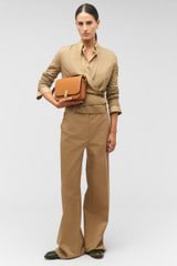 Profile view of model wearing the Oroton Flat Front Pant in Dark Camel and 65% polyester, 35% cotton for Women