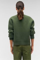 Profile view of model wearing the Oroton Knit Bomber in Green Olive and 100% wool for Women
