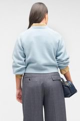 Profile view of model wearing the Oroton Crop Crew Sweater in Windmill Blue and 100% wool for Women