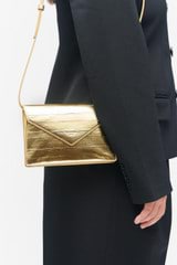 Profile view of model wearing the Oroton Mia Texture Clutch in Gold Metallic and Metallic textured leather for Women