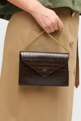 Profile view of model wearing the Oroton Mia Texture Clutch in Mahogany Croc and Textured leather for Women