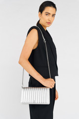 Profile view of model wearing the Oroton Fay Medium Chain Crossbody in Silver and Metallic Leather for Women