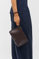 Profile view of model wearing the Oroton Ellis Pouch in Mahogany and Smooth leather for Women
