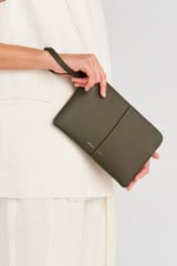 Profile view of model wearing the Oroton Lilly Medium Zip Pouch in Olive and Pebble leather for Women