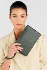 Profile view of model wearing the Oroton Lilly Medium Zip Pouch in Fern and Pebble leather for Women