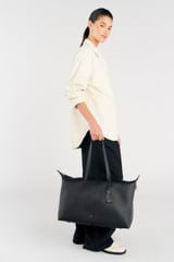 Profile view of model wearing the Oroton Lilly Weekender Tote in Black and Pebble leather for Women