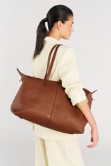 Profile view of model wearing the Oroton Lilly Weekender Tote in Cognac and Pebble leather for Women