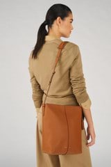 Profile view of model wearing the Oroton Lilly Hobo Bag in Cognac and Smooth leather for Women
