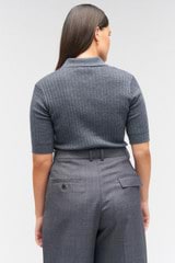 Profile view of model wearing the Oroton Stitch Rib Polo in Charcoal Marle and 100% wool for Women