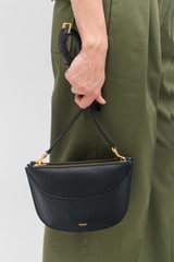 Profile view of model wearing the Oroton Florence Crossbody in Black and Smooth leather for Women