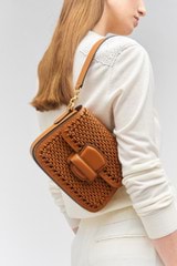 Profile view of model wearing the Oroton Carter Collectable Small Day Bag in Amber and Smooth leather, handwoven leather for Women