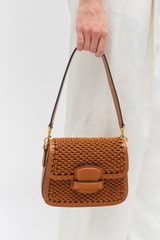 Profile view of model wearing the Oroton Carter Collectable Small Day Bag in Amber and Smooth leather, handwoven leather for Women