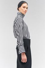 Profile view of model wearing the Oroton High Neck Check Blouse in Black/White and 92% silk, 8% spandex for Women