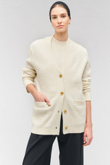 Profile view of model wearing the Oroton Button Detail Long Line Cardigan in Cream and 100% wool for Women