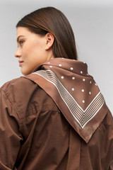 Profile view of model wearing the Oroton Bandana Silk Scarf in Chocolate and 100% silk for Women
