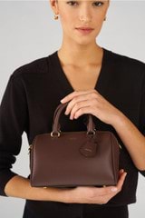 Profile view of model wearing the Oroton Harvey Mini Barrel in Chestnut and Smooth leather for Women