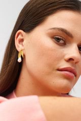 Profile view of model wearing the Oroton Alma Studs in Worn Gold/Pearl and Brass for Women